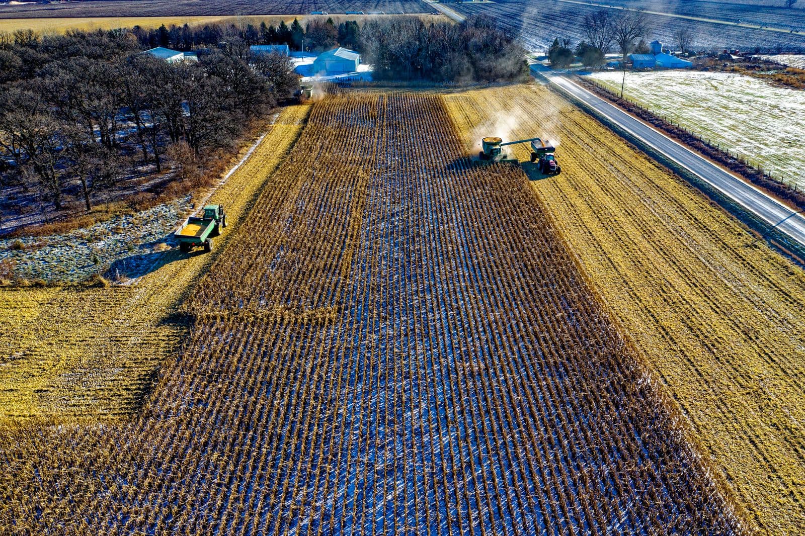 Aerial view of machinery harvesting rows of crops